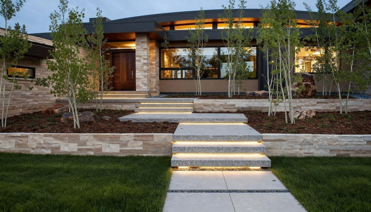 Floating granite steps leading to a modern home with stone walls and landscaping