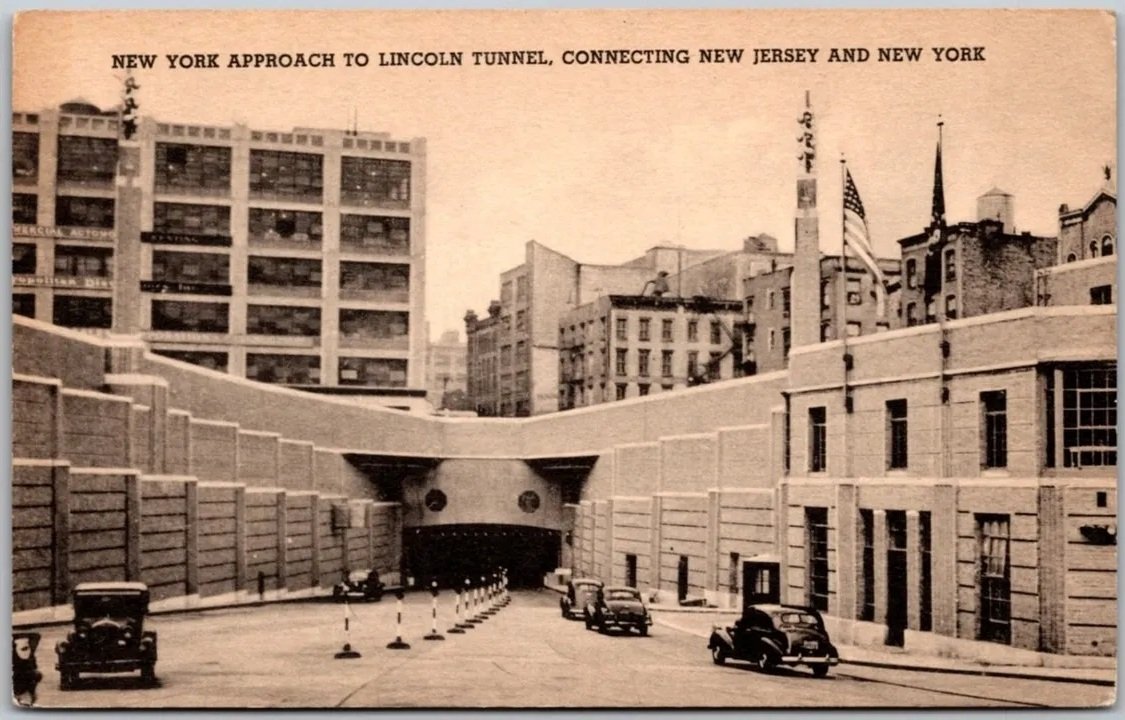Vintage postcard of the New York approach to the Lincoln Tunnel, with old cars driving toward the tunnel entrance.
